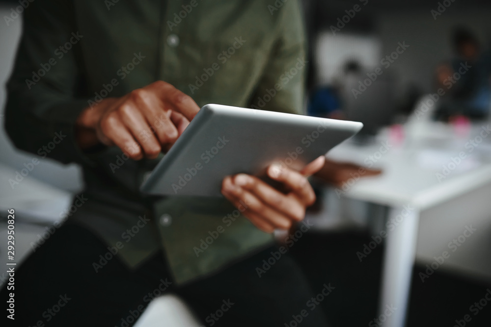 Close-up of businessman's finger touching screen of a digital tablet at the office - obrazy, fototapety, plakaty 