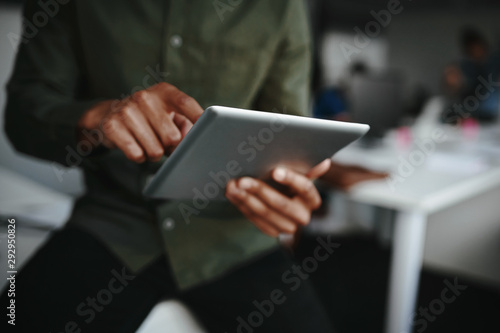 Close-up of businessman's finger touching screen of a digital tablet at the office