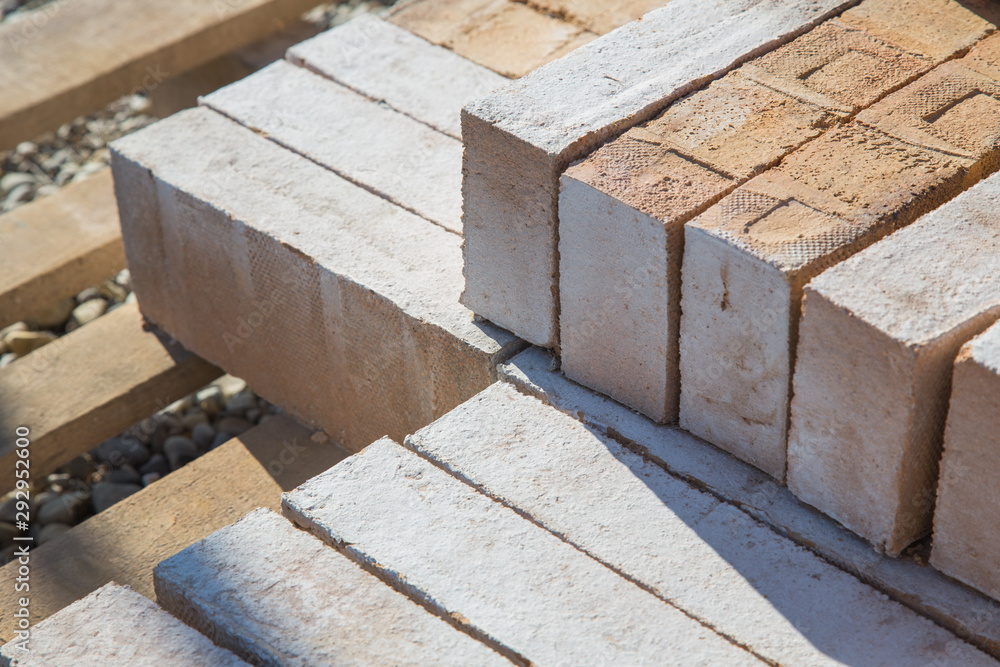 Auf der Baustelle: Ziegel aus Ton auf der Holzpalette Auf der Baustelle: Ziegel aus Ton auf der Holzpalette