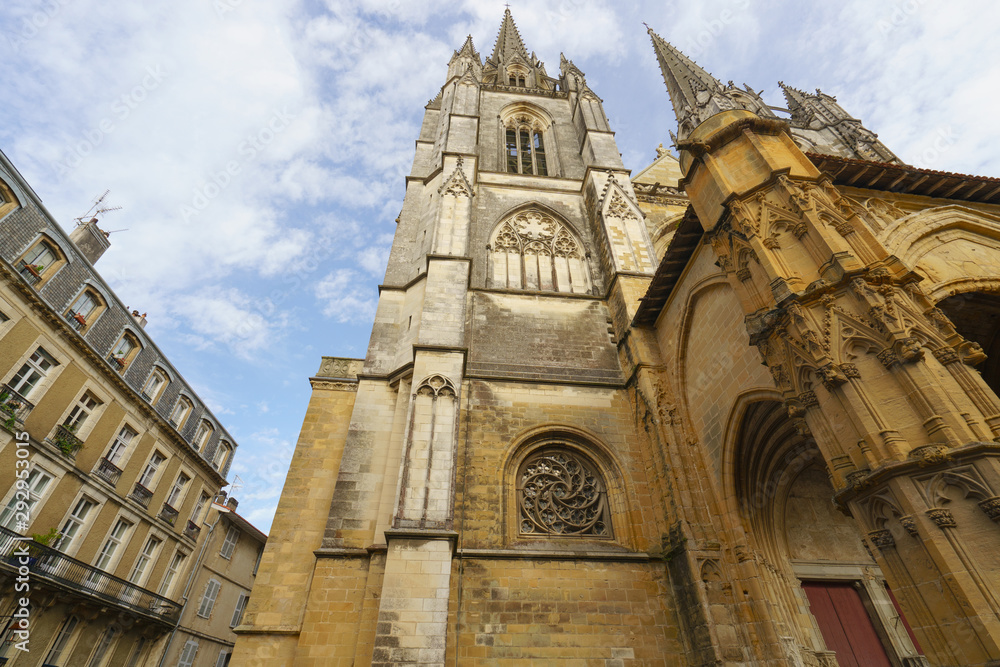 Architecture of Bayonne city. High medieval cathedral / Gothic facade of Sainte-Marie and residential houses nearby. Touristic concept in Nouvelle Aquitaine. Closing touristic season. 