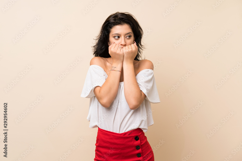 Young woman over isolated background nervous and scared putting hands to mouth Young woman over isolated background nervous and scared putting hands to mouth