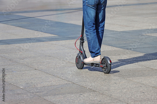 Man riding a kick scooter at the city square