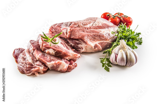 Pork neck raw meat with garlic parsley herbs tomatoes and rosemary isolated on white background