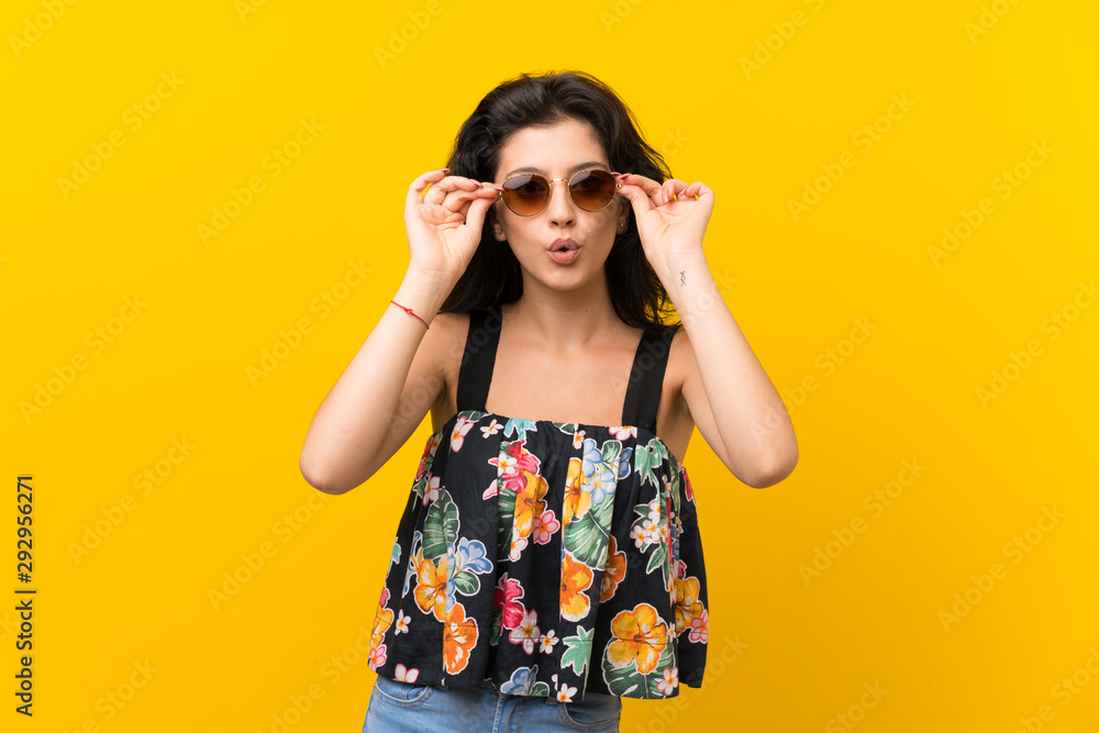 Young woman over isolated yellow background with glasses Young woman over isolated yellow background with glasses