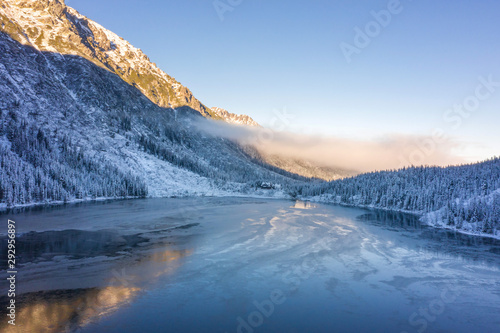 Fototapeta Naklejka Na Ścianę i Meble -  Winter ice lake in snowy mountains. Christmas background. Frosty weather in highlands. Beautiful scenic landscape of clear icy in Tatra mountains
