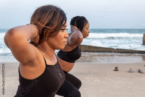 Two young African lady doing squats by the beach