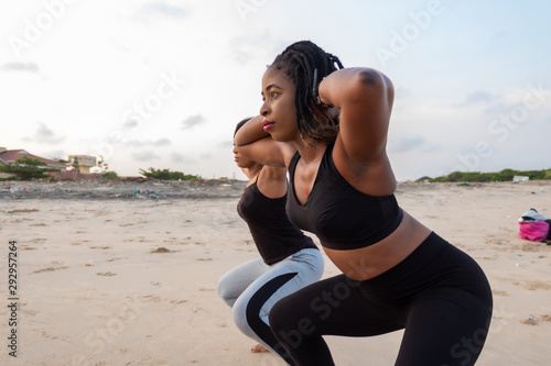 Two young African lady doing squats by the beach
