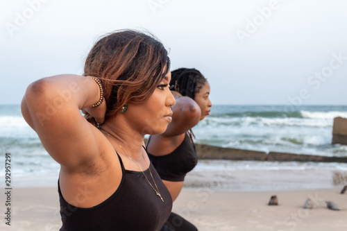 Two young African lady doing squats by the beach