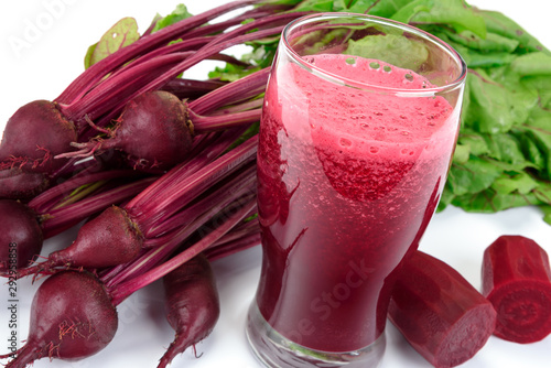 Beetroots with green leaves and fresh beet juice from organic farm in a glass on a white background.