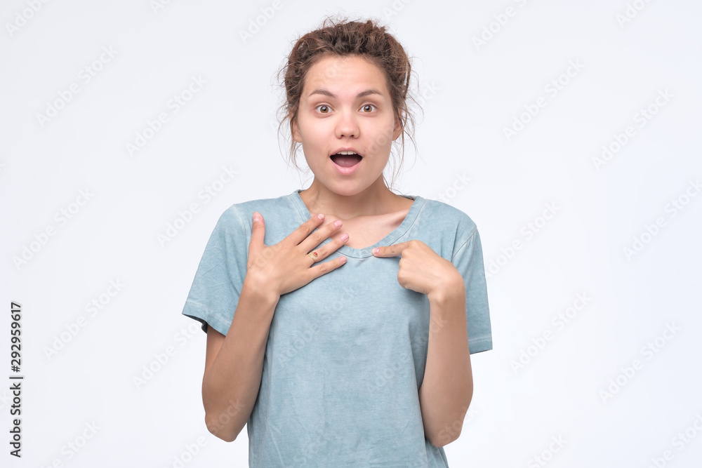 Asian woman pointing at herself with index finger, gazing at camera. Asian woman pointing at herself with index finger, gazing at camera.