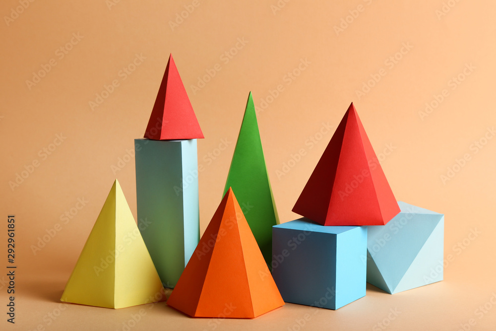 Colorful paper geometric figures on beige background Colorful paper geometric figures on beige background
