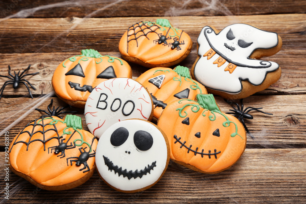 Halloween gingerbread cookies with spiders on brown wooden table Halloween gingerbread cookies with spiders on brown wooden table