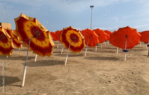 Obraz na płótnie Sonnenschirme trocknen am Strand am Saisonende w salonie
