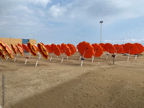 Obraz na płótnie Sonnenschirme trocknen am Strand am Saisonende w salonie