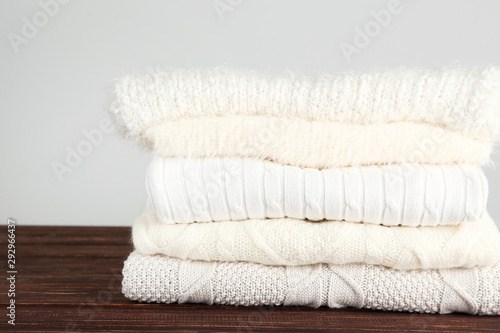 Folded knitted sweaters on grey background © 5second
