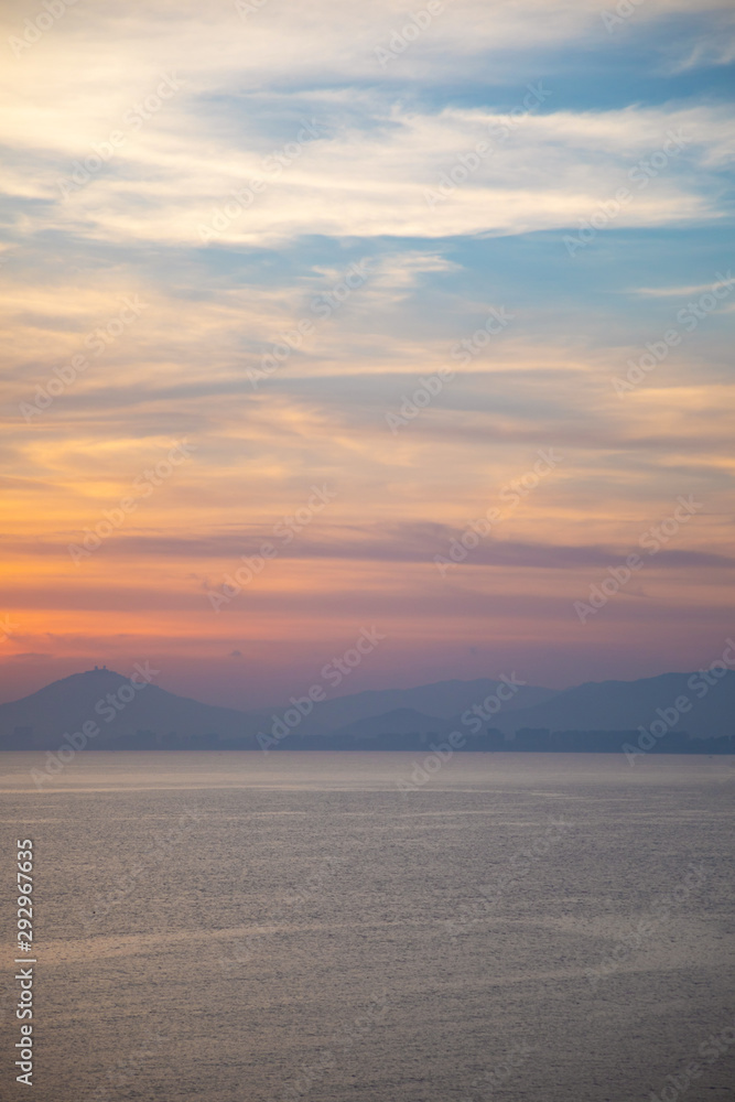 A peaceful scene of a calm ocean and gentle sunset