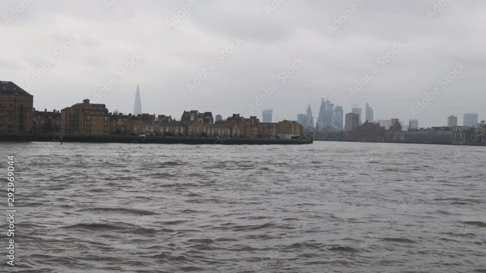 Riverside with residential houses and London cityscape in the background. Riverside with residential houses and London cityscape in the background.