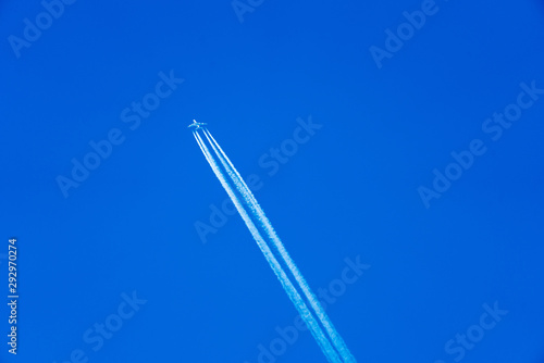 Flieger am strahlend blauen Himmel mit Kondensstreifen