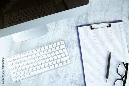 glasses on document with computer on desk