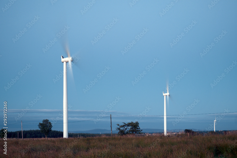 Windmills in the field in the evening on the background of blue sky. West Lothian, Scotland, UK Windmills in the field in the evening on the background of blue sky. West Lothian, Scotland, UK
