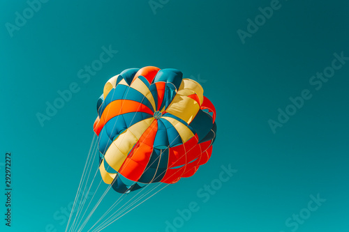 A multi-colored dome of a parachute in the sky as a background.