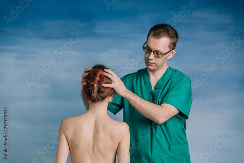 Принти на полотні The male doctor examines the patient woman 27 years old on the blue background