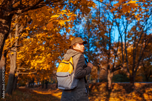 Tourist with backpack walking in autumn forest. Young woman travel at sunset © maryviolet
