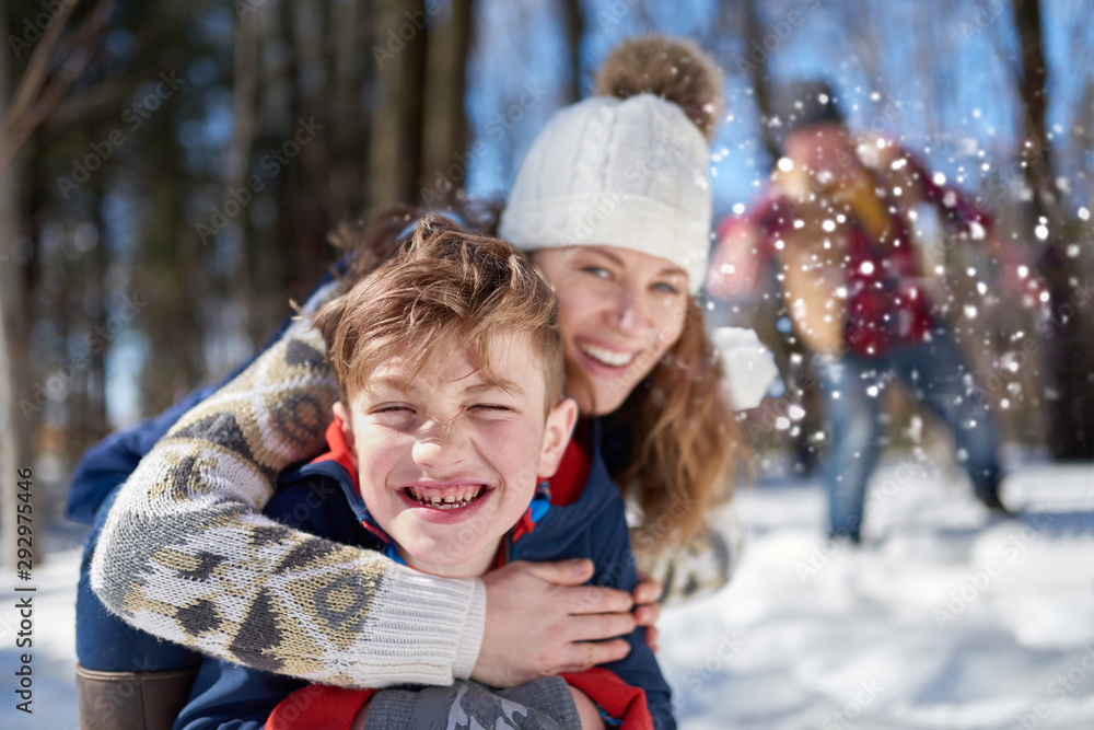 Happy family with son enjoying playing in fresh snow during wintertime and having a snowball fight Happy family with son enjoying playing in fresh snow during wintertime and having a snowball fight
