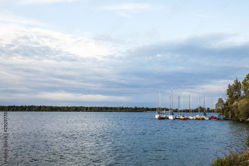 Obraz premium Sunset at the lake with anchored sailboats