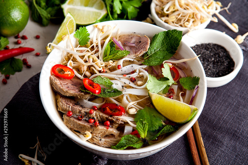 Pho Noodle Soup on dark table. Beef with Chilli, Basil, Rice Noodles, Bean Shoots showing noodles photo