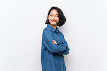 Asian young woman over isolated white background with arms crossed and happy