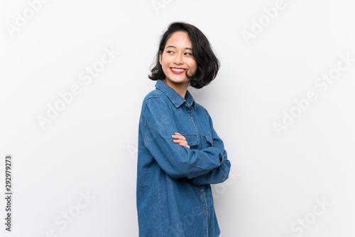 Asian young woman over isolated white background with arms crossed and happy photo