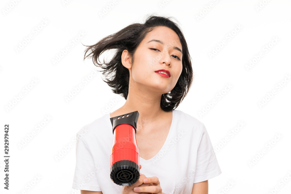 Asian young woman over isolated background with hairdryer Asian young woman over isolated background with hairdryer