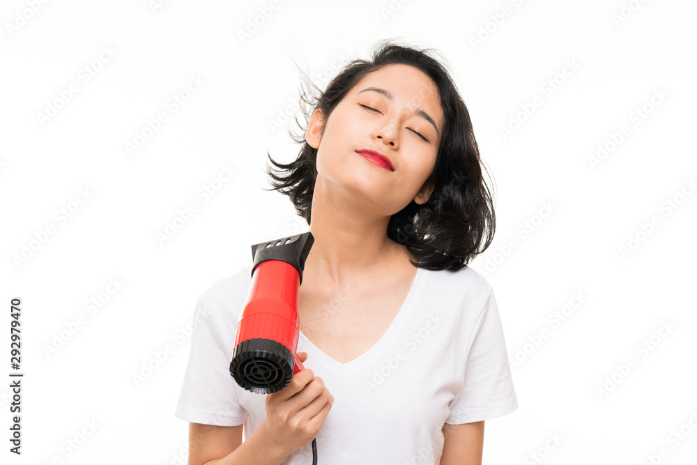 Asian young woman over isolated background with hairdryer Asian young woman over isolated background with hairdryer