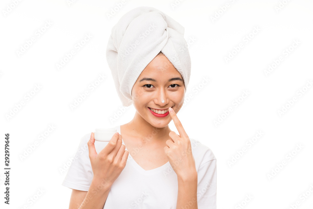 Asian young woman over isolated background with moisturizer Asian young woman over isolated background with moisturizer