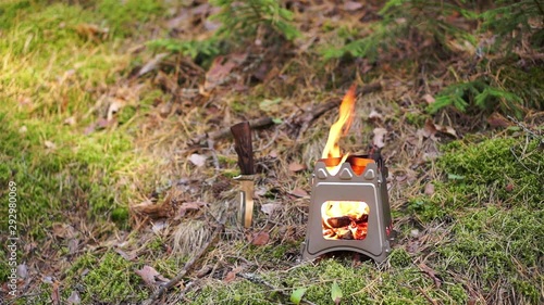 Wood burning folding twig stove in forest background