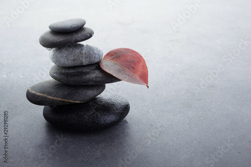 zen stones in balanced pile on dark grey background