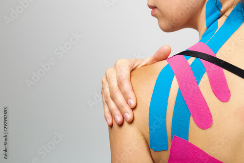 Kinesiotaping, kinesiology. Female athlete with kinesiotape, muscle tape on shoulder photo