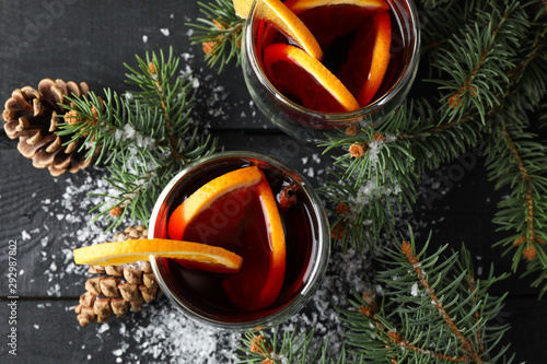 Glasses of tasty mulled with orange on decorated background, top view