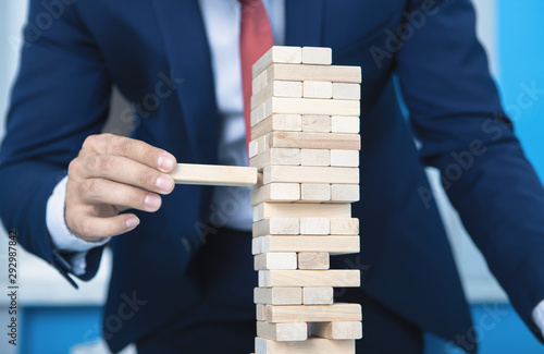 businessman makes a pyramid with empty wooden cubes; business concept