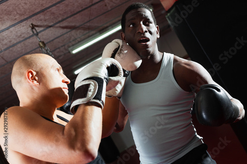 Two athlete men in sportswear exercising boxing sparring in the hall © JackF