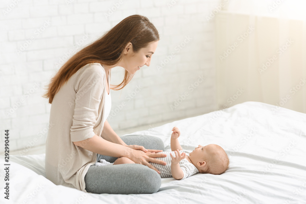Young woman enjoying spending time with her newborn baby Young woman enjoying spending time with her newborn baby