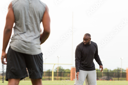 American Football coach training a young athlete.