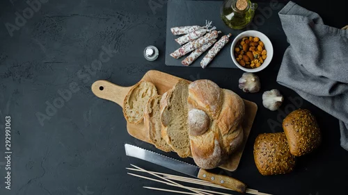 Panel kuchenny z motywem Pyszny chrupiący chleb z salami, orzechami, czosnkiem i oliwą. Widok z góry.