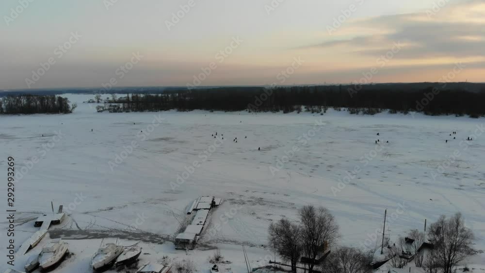 aerial view of sunset with anglers on a frozen lake aerial view of sunset with anglers on a frozen lake
