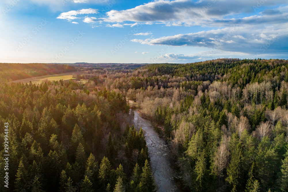 Aerial view of a river and green forest on a bright day with blue sky. Amata, Latvia. Aerial view of a river and green forest on a bright day with blue sky. Amata, Latvia.