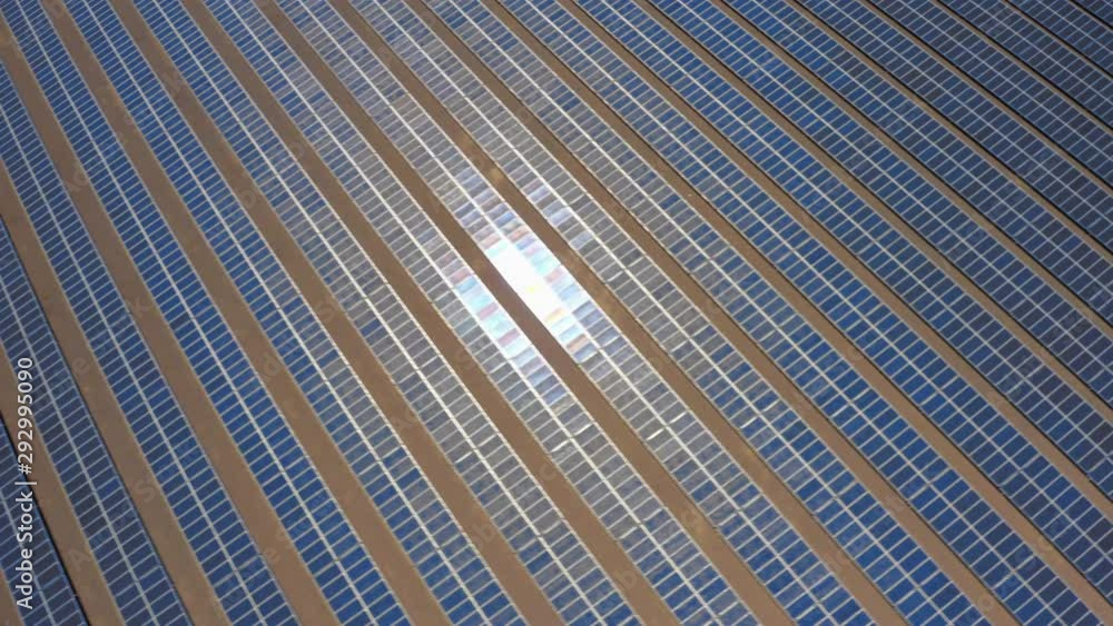 Sparkling solar panels. Drone observation of the reflection on the blue solar cell rows located in Nevada solar farm. Working batteries under afternoon sun rays. Eco friendly industry on its work Sparkling solar panels. Drone observation of the reflection on the blue solar cell rows located in Nevada solar farm. Working batteries under afternoon sun rays. Eco friendly industry on its work