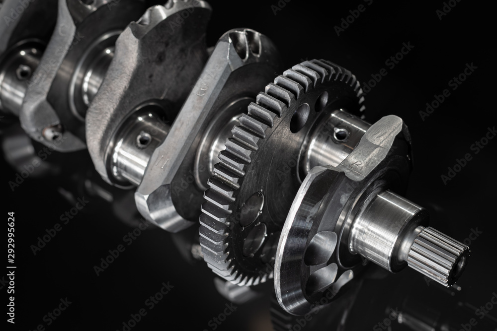 high performance factory racing crankshaft. set on a black reflective background with different lighting. high performance factory racing crankshaft. set on a black reflective background with different lighting.