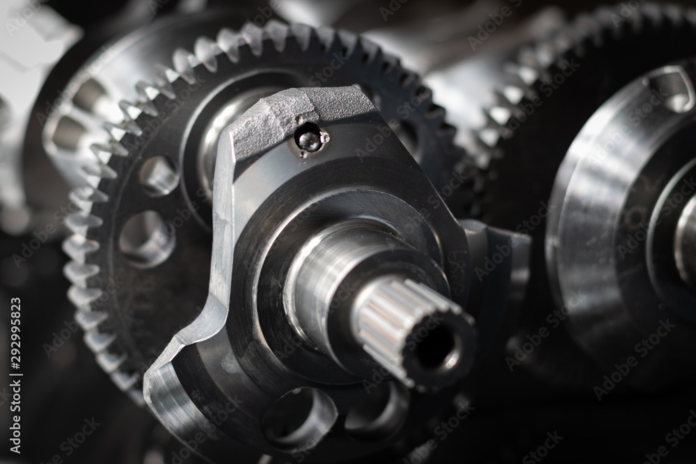 high performance factory racing crankshaft. set on a black reflective background with different lighting. high performance factory racing crankshaft. set on a black reflective background with different lighting.
