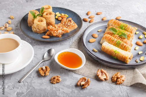 Set of various traditional arabic sweets: baklava, kunafa, basbus in  ceramic plates on a gray concrete background. top view. photo